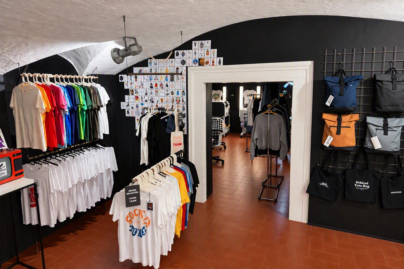 Interno del negozio Velvet Goldmine a Firenze con t-shirt colorate, shopper e laboratorio